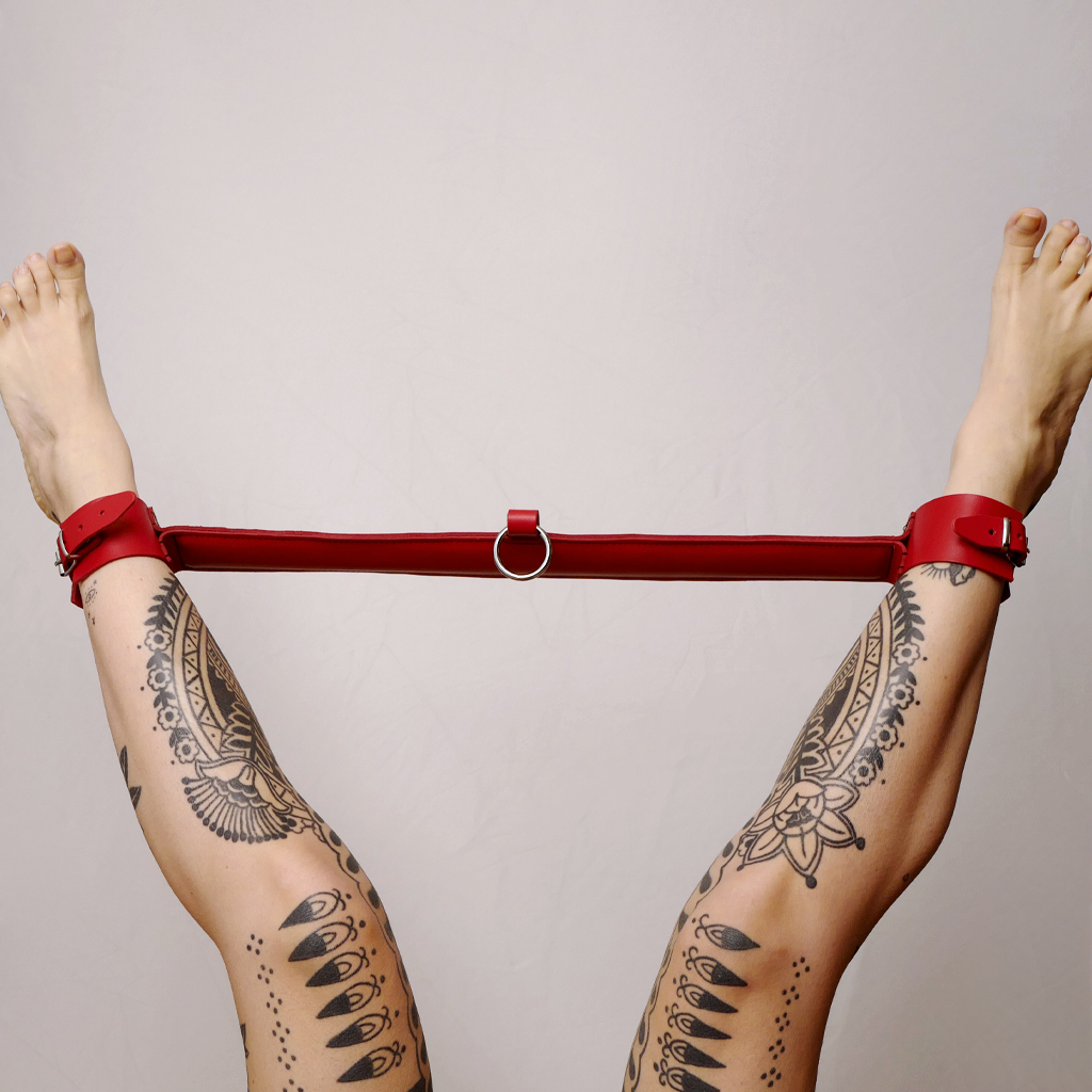 Barre d&#039;écartement en cuir rouge, idéale pour contraindre de multiples façons.