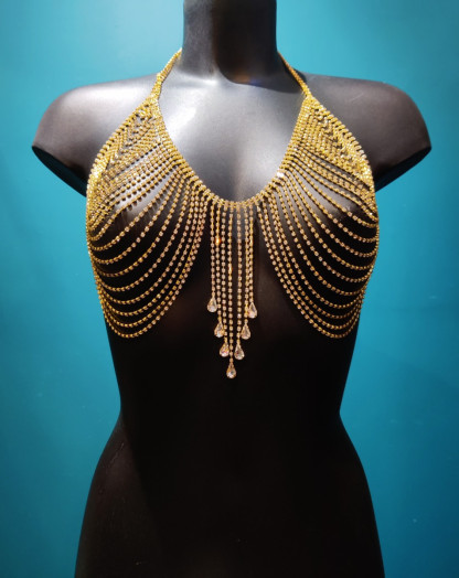 Bijou de poitrine en maille dorée à strass avec pendant en forme de gouttes en cristal qui ornent l'entre-seins.