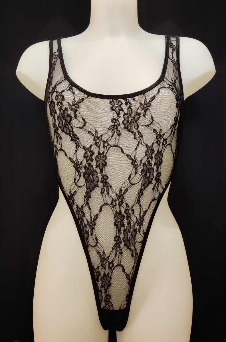 Body string très échancré en dentelle transparente. Son décolleté rond met en lumière la poitrine tandis que sa coupe échancrée dévoile les hanches.