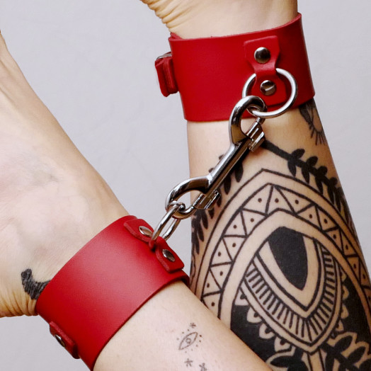 Cette paire de chevillères en cuir rouge avec son mousqueton en acier permet de contraindre dans le confort.
