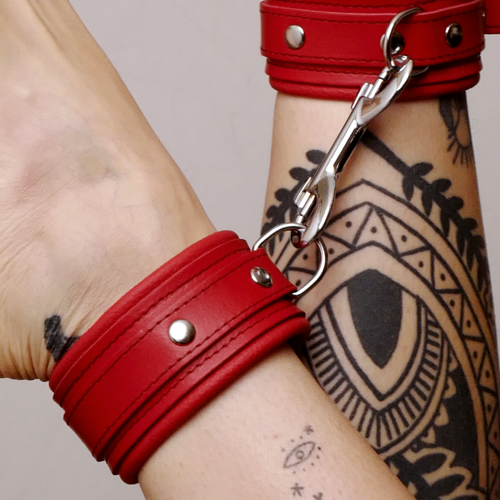 Cette paire de chevillères en cuir rouge avec son mousqueton en acier permet de contraindre dans le confort.