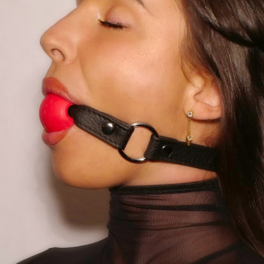 Gag-ball pour jeux de contrainte en cuir souple noir avec boule en latex rouge d'un diamètre de 4cm environ.
