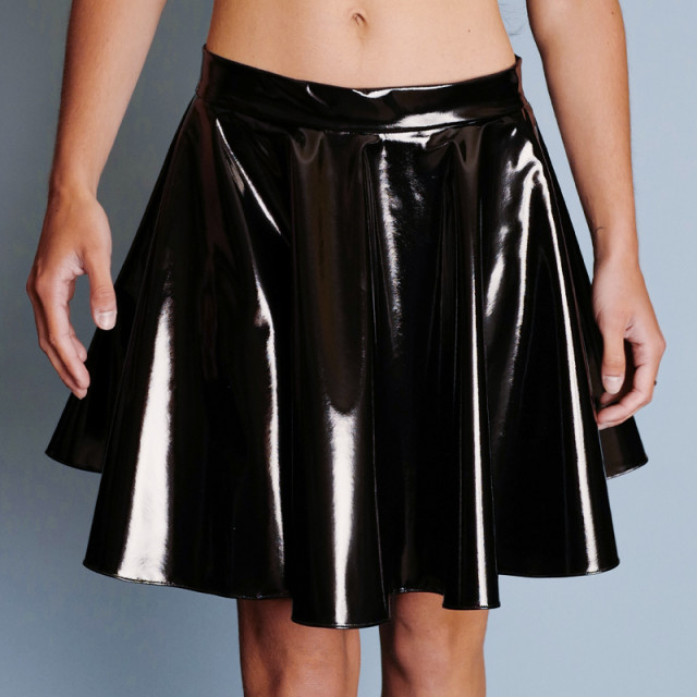 Jupe patineuse en vinyle noir brillant. Sa ceinture fine et élastique marque la taille tandis que ses volants subliment les hanches.