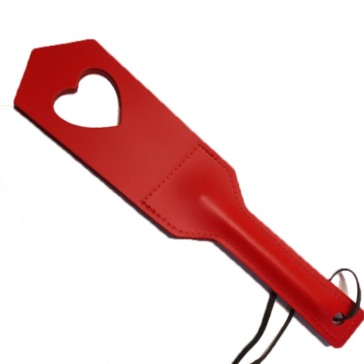 Paddle en cuir rouge avec embout fendu et découpe en forme de cœur. Sa sensation d'impact est amplifiée par le bruit.
